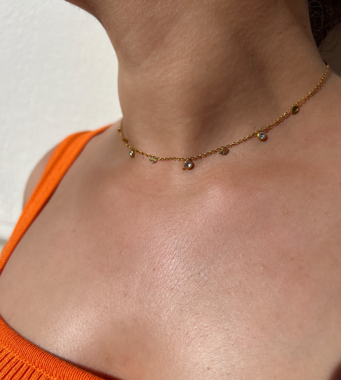 Collier choker en acier inoxydable doré orné de pampilles et de cristaux scintillants, porté autour du cou féminin. Bijou délicat et raffiné de la collection Bisou Bijoux Paris.