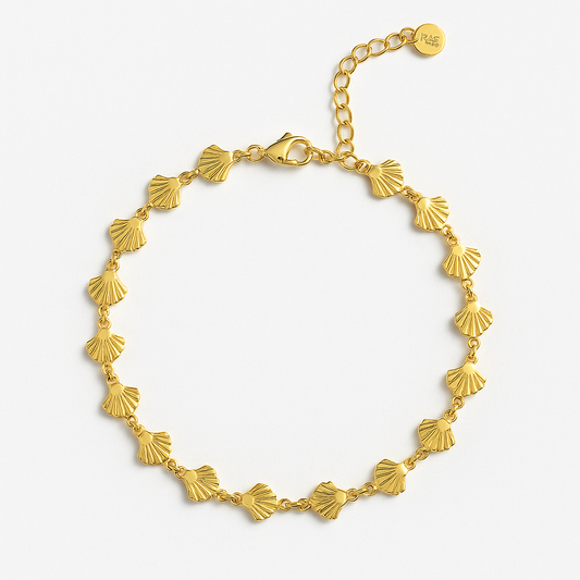 Bracelet de cheville doré avec motifs coquillages élégants, fond blanc professionnel
