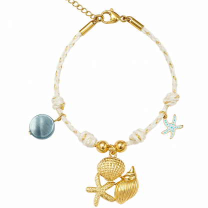 Collection de bracelets en acier inoxydable doré avec charms coquillage, étoile de mer, ananas, palmier et perles.