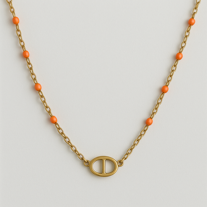 Collier Ovalia en acier inoxydable doré avec perles oranges et pendentif ovale, bijou élégant et minimaliste, hypoallergénique et résistant à l'eau.