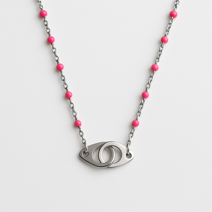 Collier Pink Eye en acier inoxydable argenté avec perles roses et pendentif œil stylisé, bijou moderne et élégant, hypoallergénique et résistant à l'eau.

